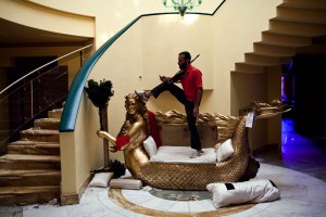 TRIPOLI, LIBYA - AUGUST 29: A Libyan Rebel stands and posed on an ornate mermaid loveseat, a wedding gift made to resemble Aisha Gaddafi, daughter of former Libyan dictator Moammar Gaddafi, while guarding Aisha's home from looters, on August 29, 2011 in Tripoli, Libya. (Photograph by Benjamin Lowy/Reportage by Getty Images)